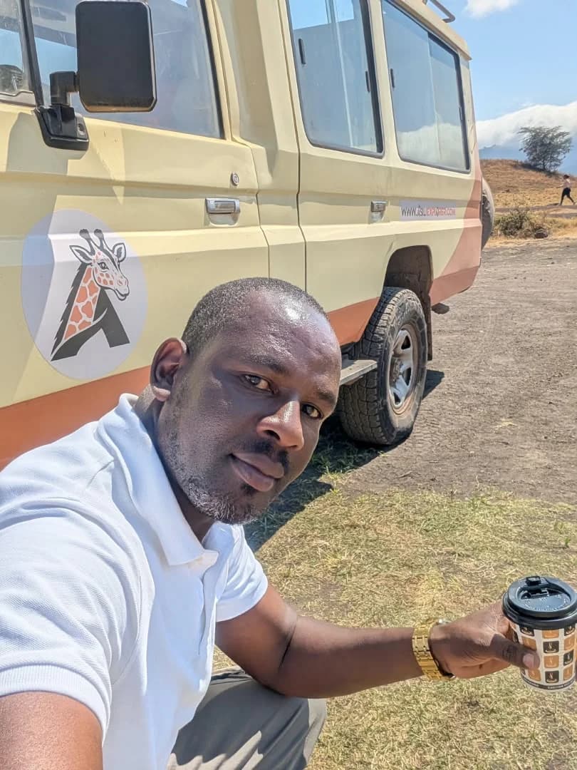 An Asili Explorer local expert beside a safari vehicle